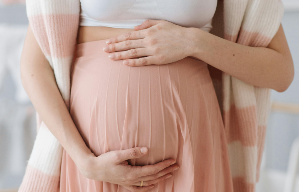 Mother Blessing - eine Schwangere hält liebevoll ihren Bauch.